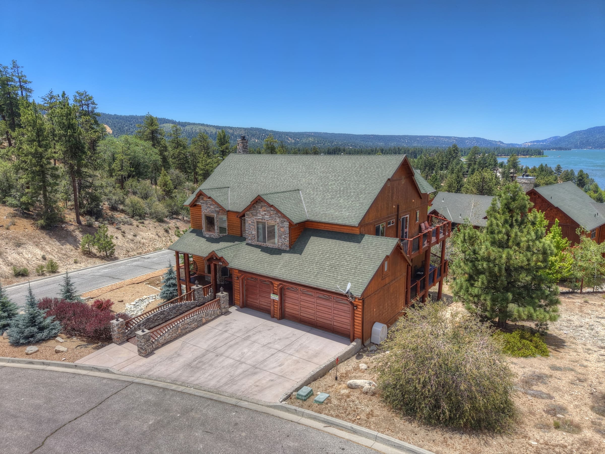 Aerial view: log-style cabin retreat with lake and mountain vistas