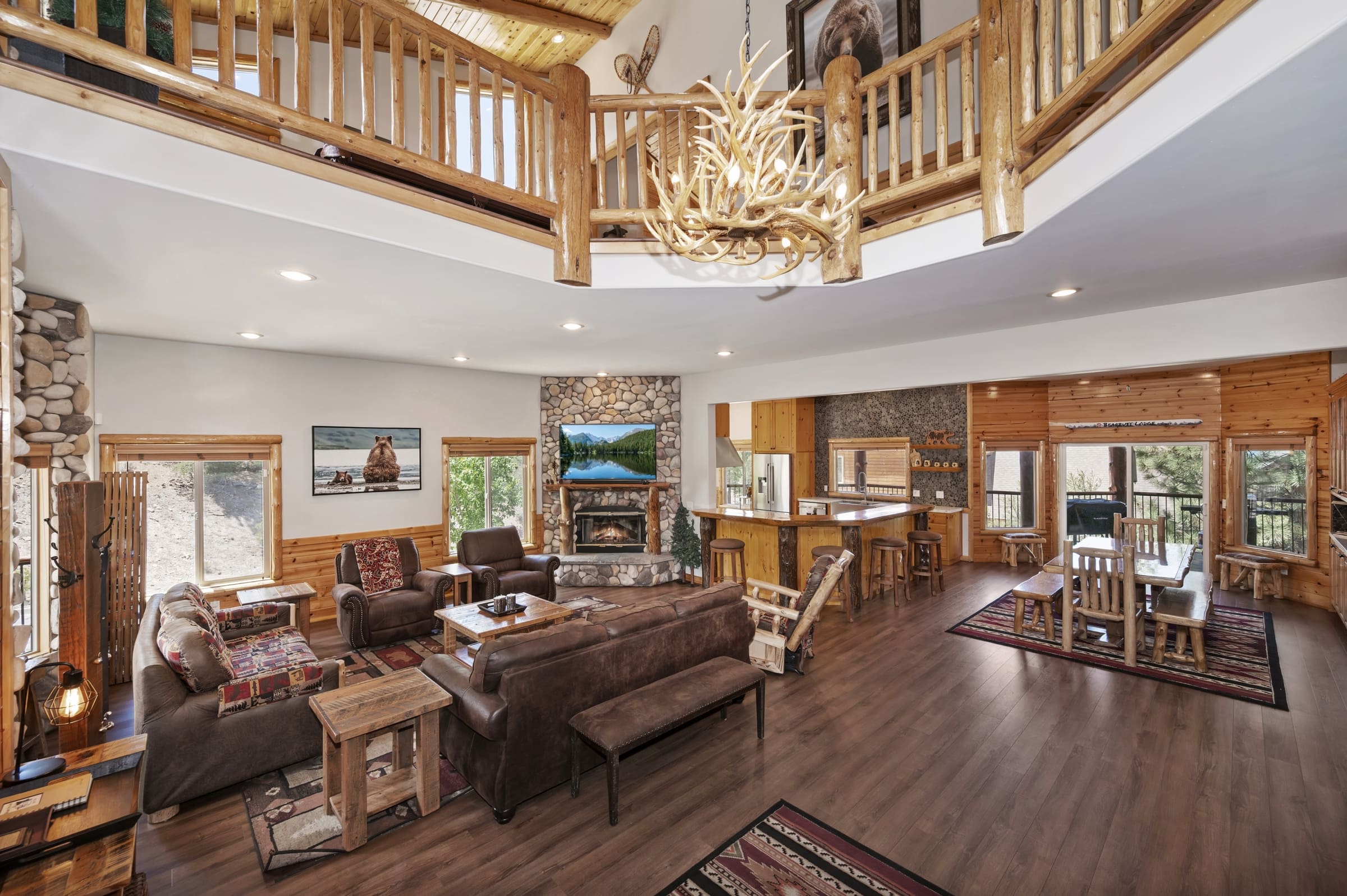 Vaulted great room with antler chandelier and stone fireplace