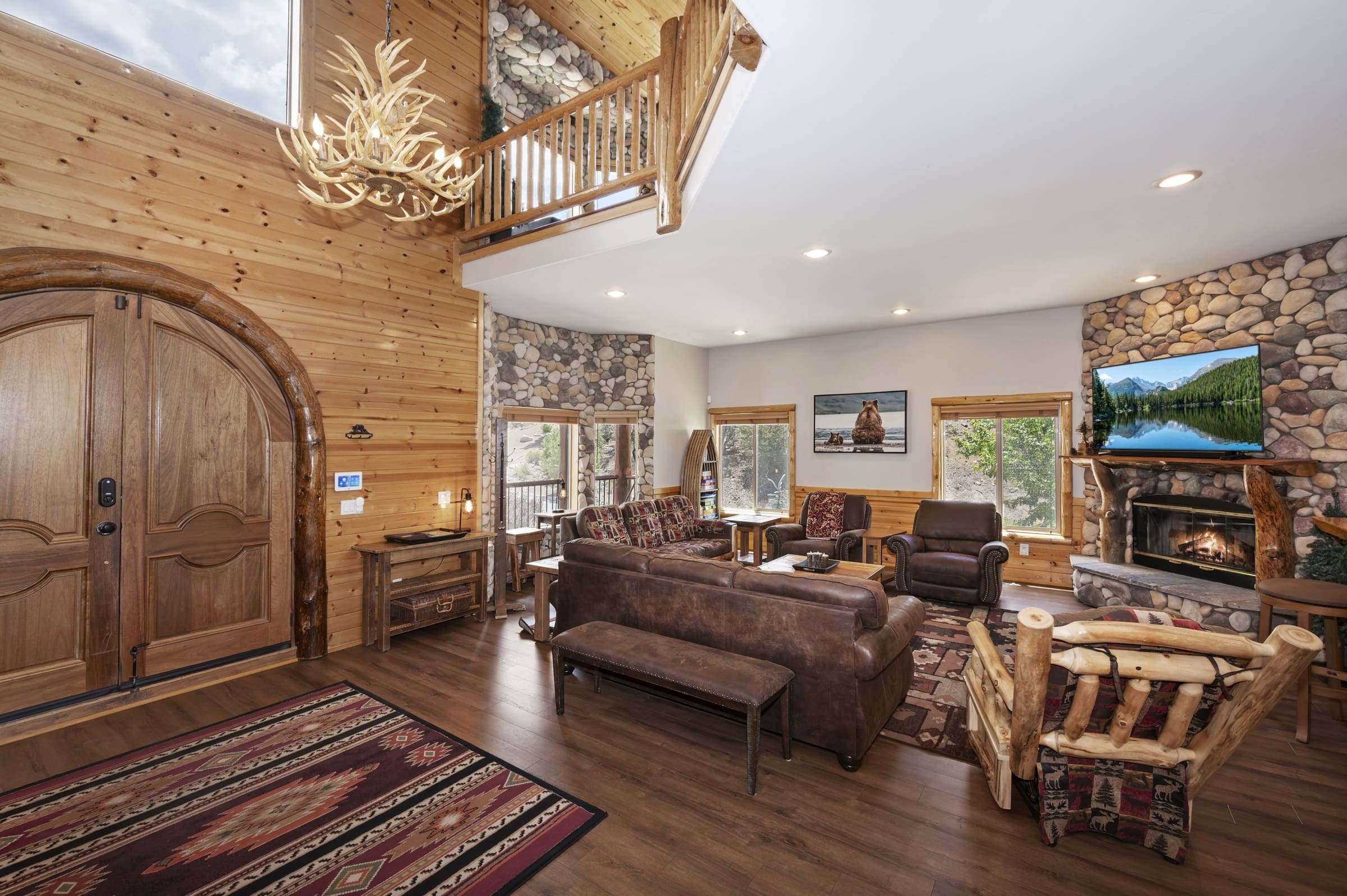 Vaulted great room with antler chandelier and stone fireplace