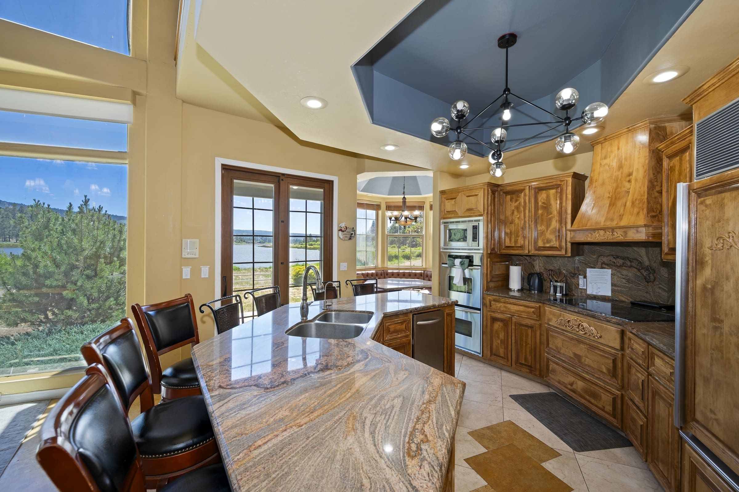 Waterfall granite island framed by lake-view windows