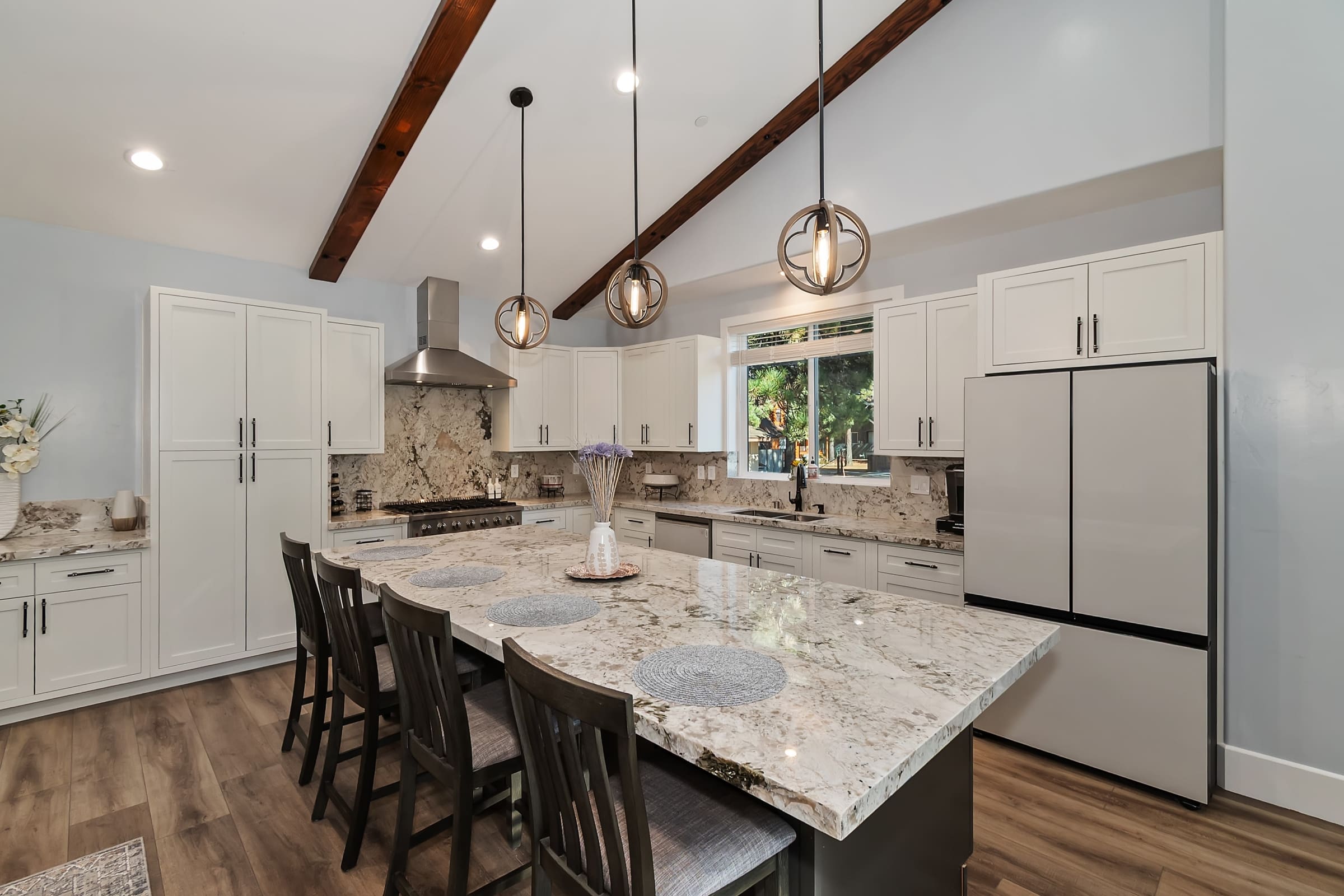 Vaulted-beam kitchen with waterfall granite island seating four