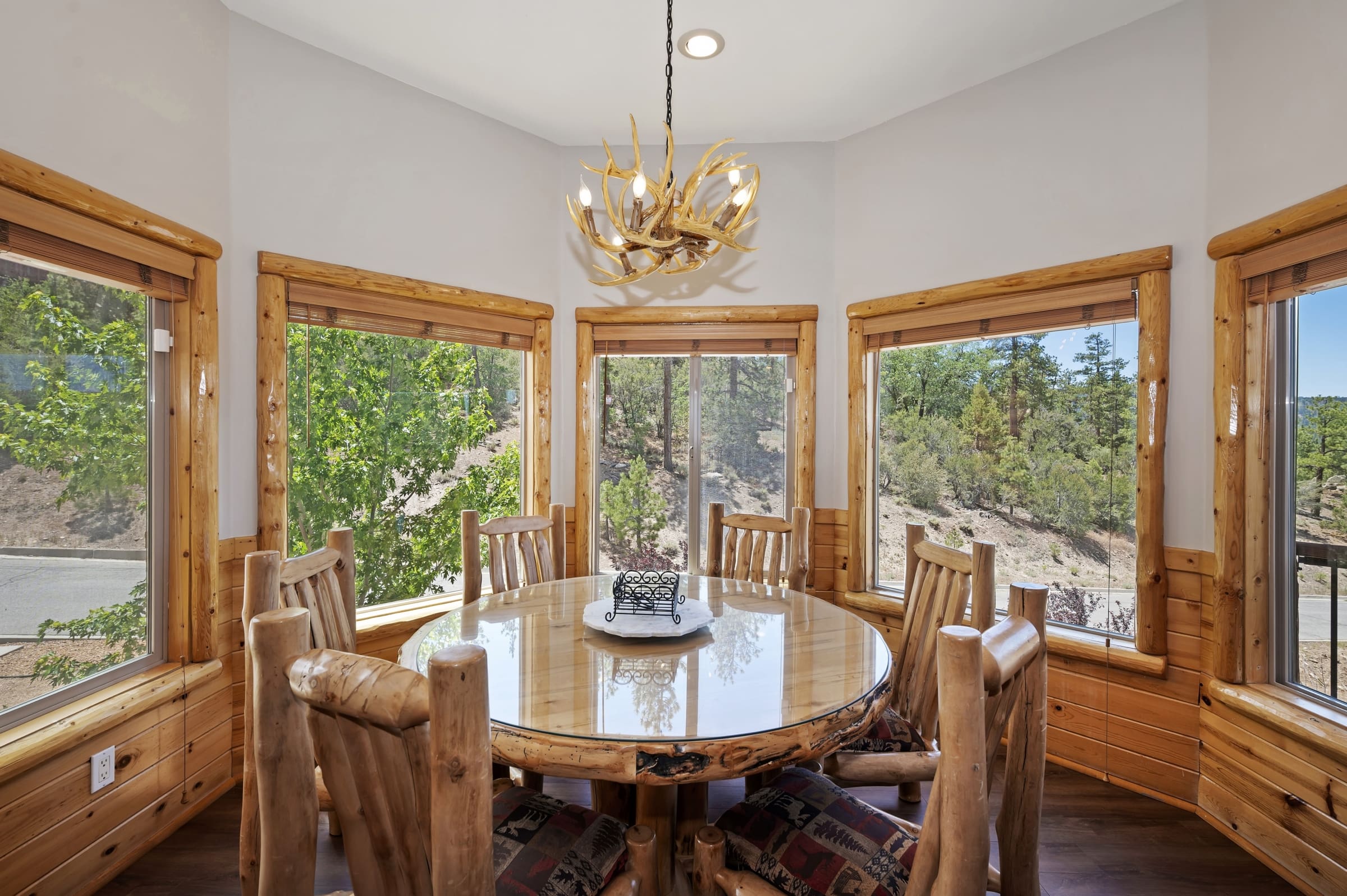 Log dining nook with antler chandelier and forest views