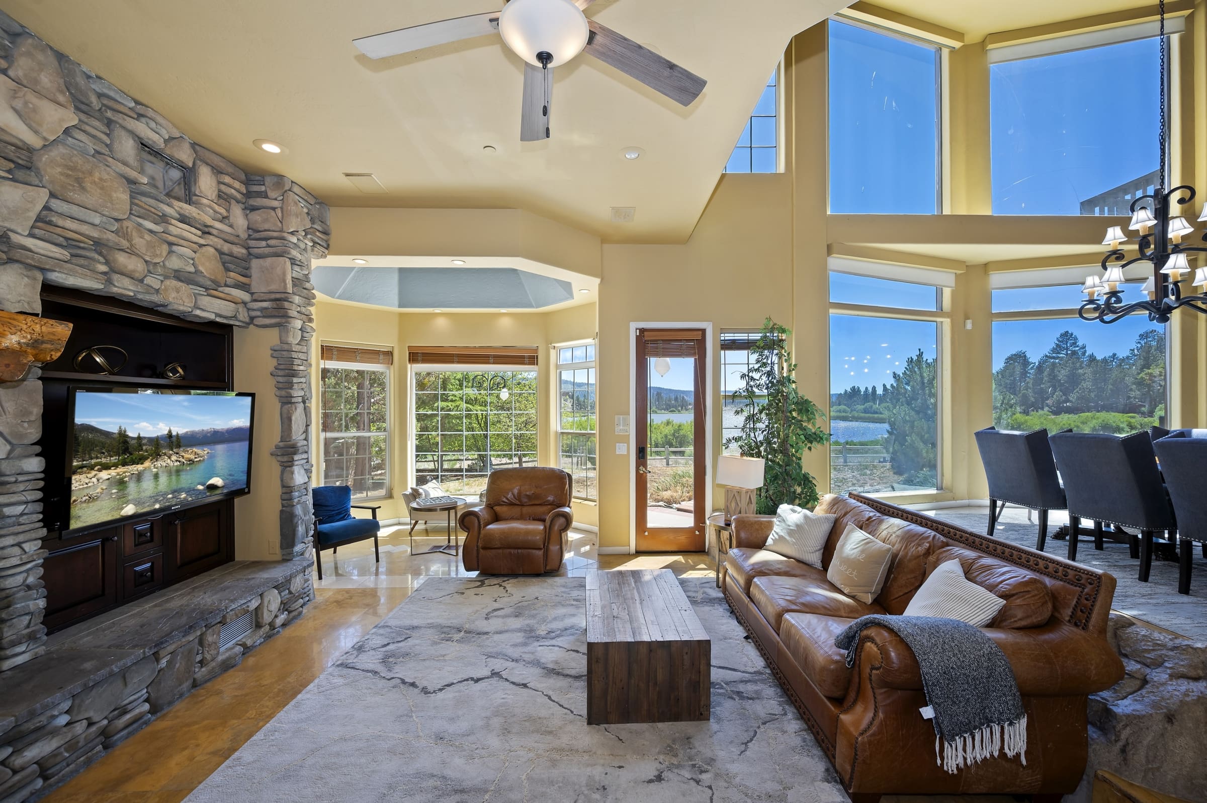 Soaring stone fireplace and floor-to-ceiling lake-view windows