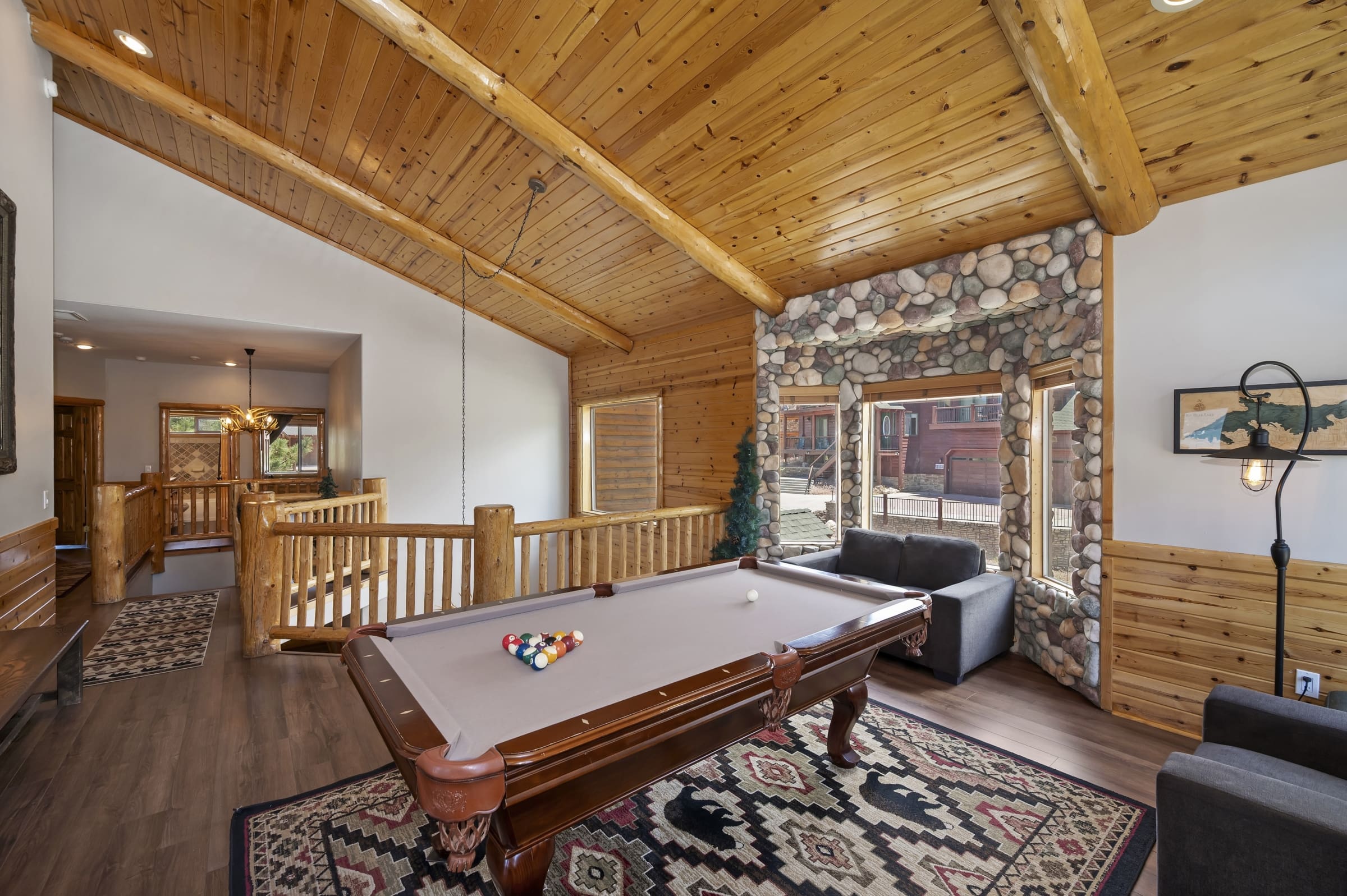 Loft game room with pool table and river-rock fireplace accent