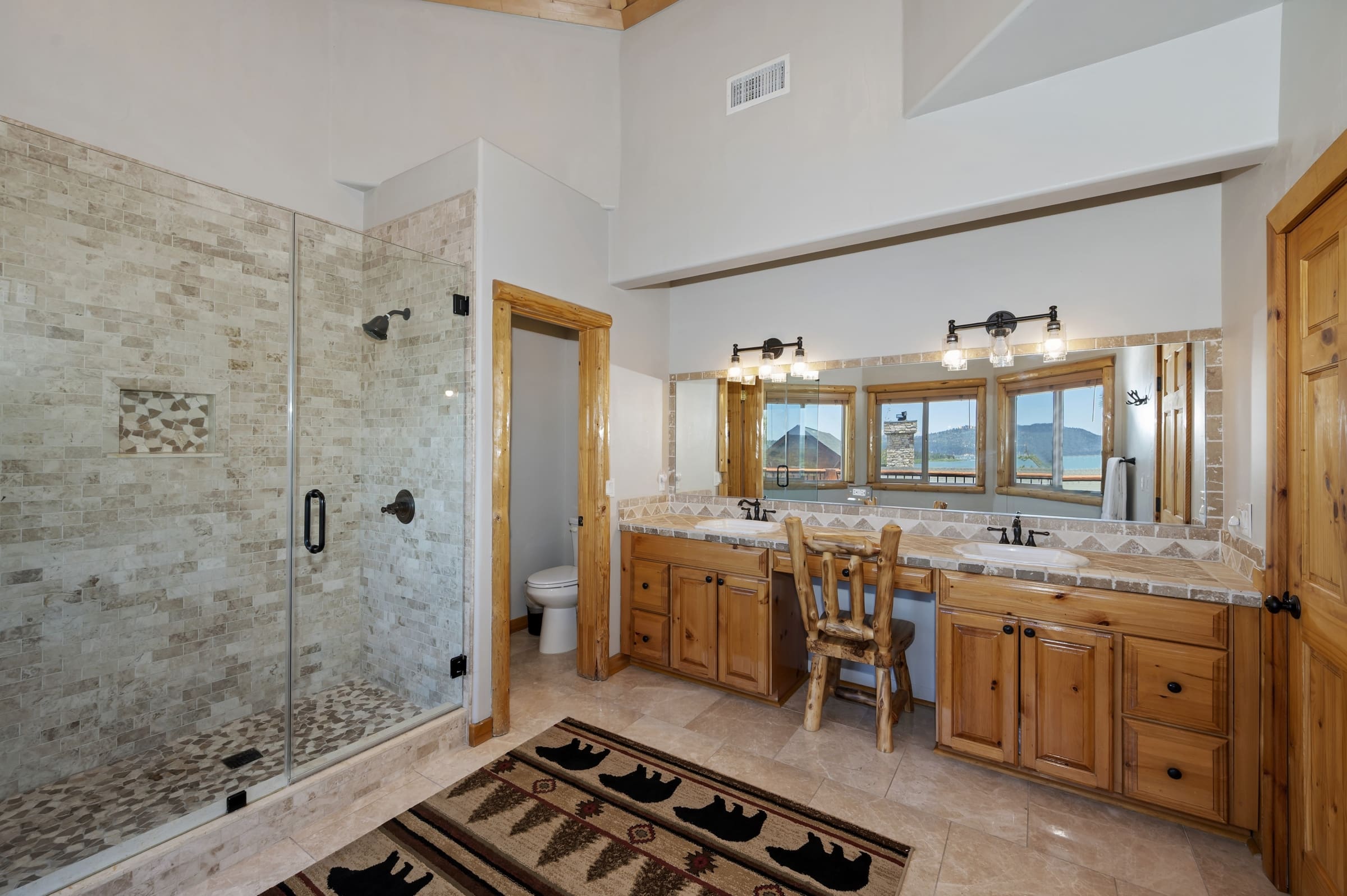 Rustic dual-vanity bath with lake and mountain views
