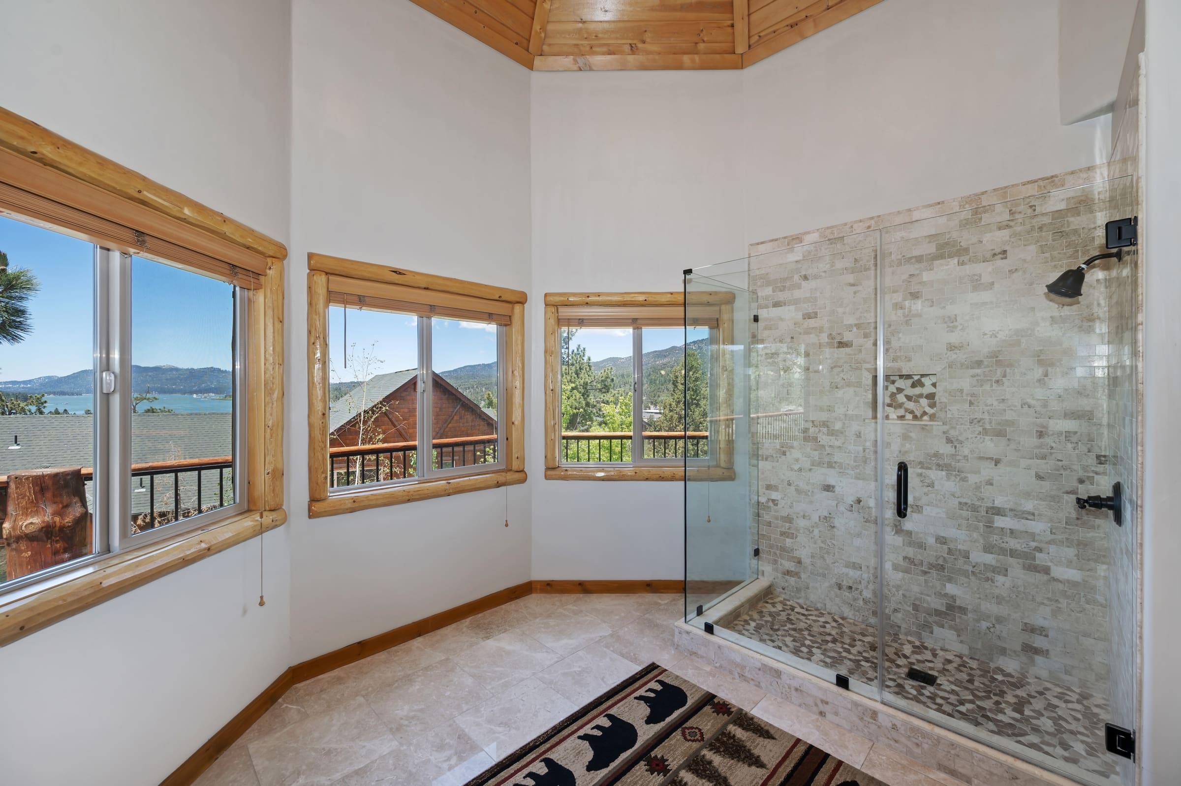 Glass shower with tiled surround and lake views