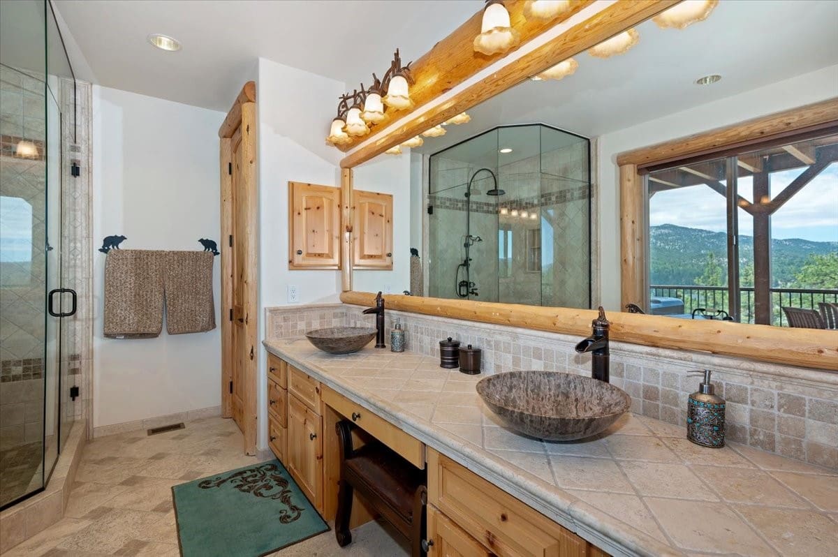 Rustic log-accented dual vessel-sink bath with mountain views