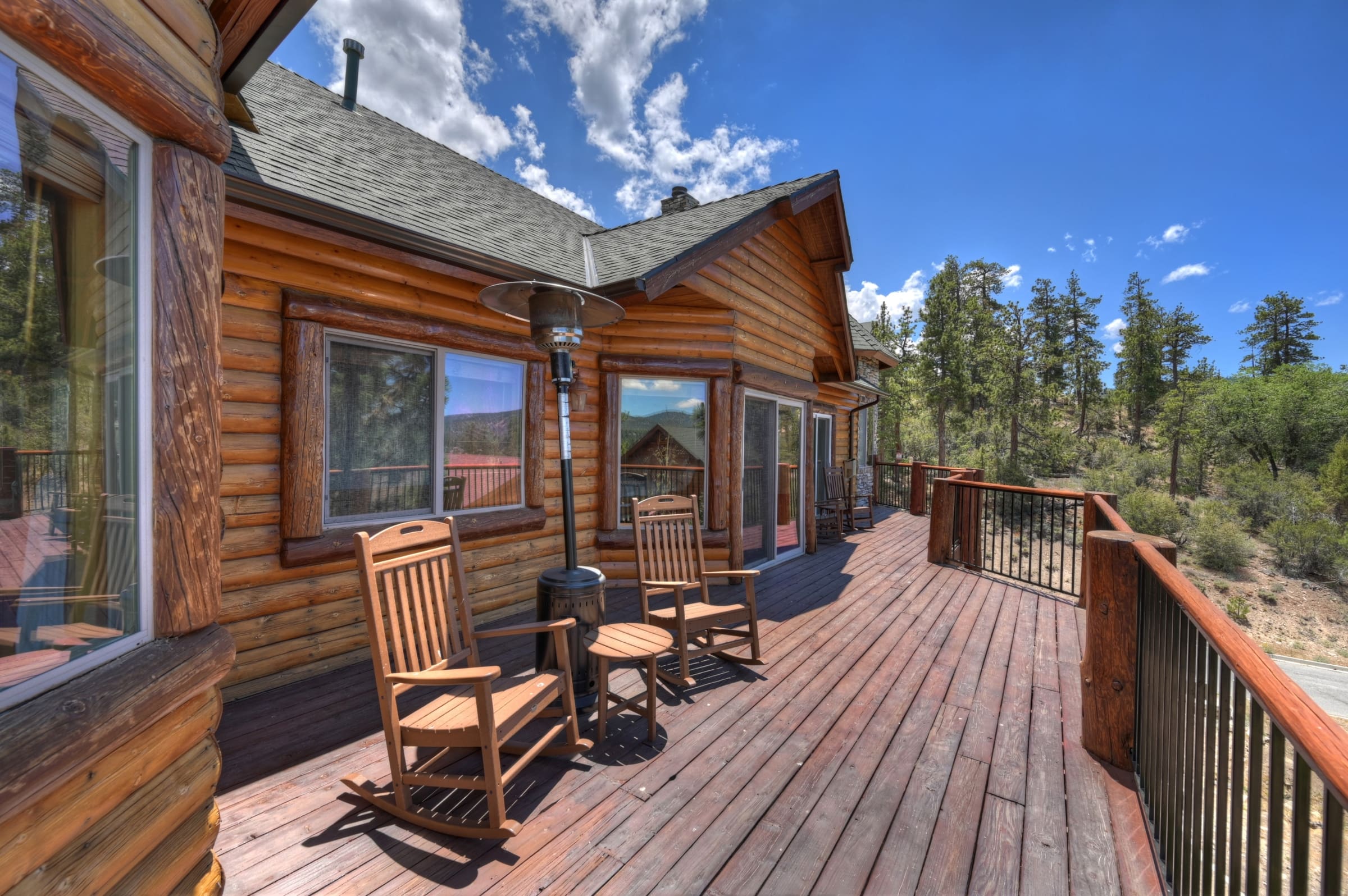 Log cabin deck with rocking chairs and pine views