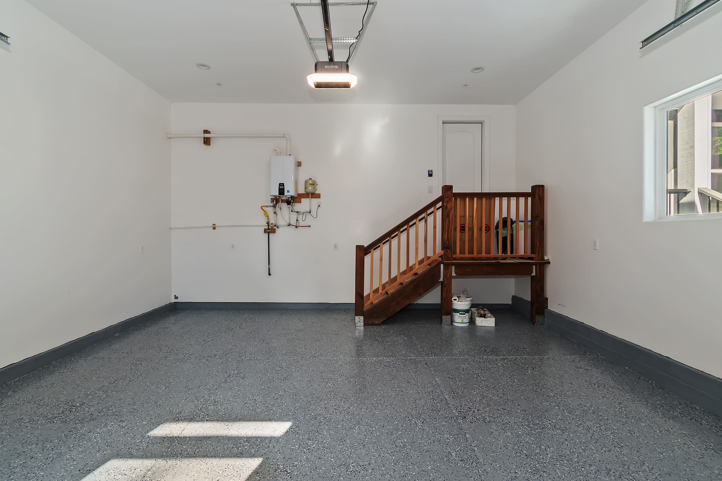 Epoxy-finished garage with staircase access to upper level