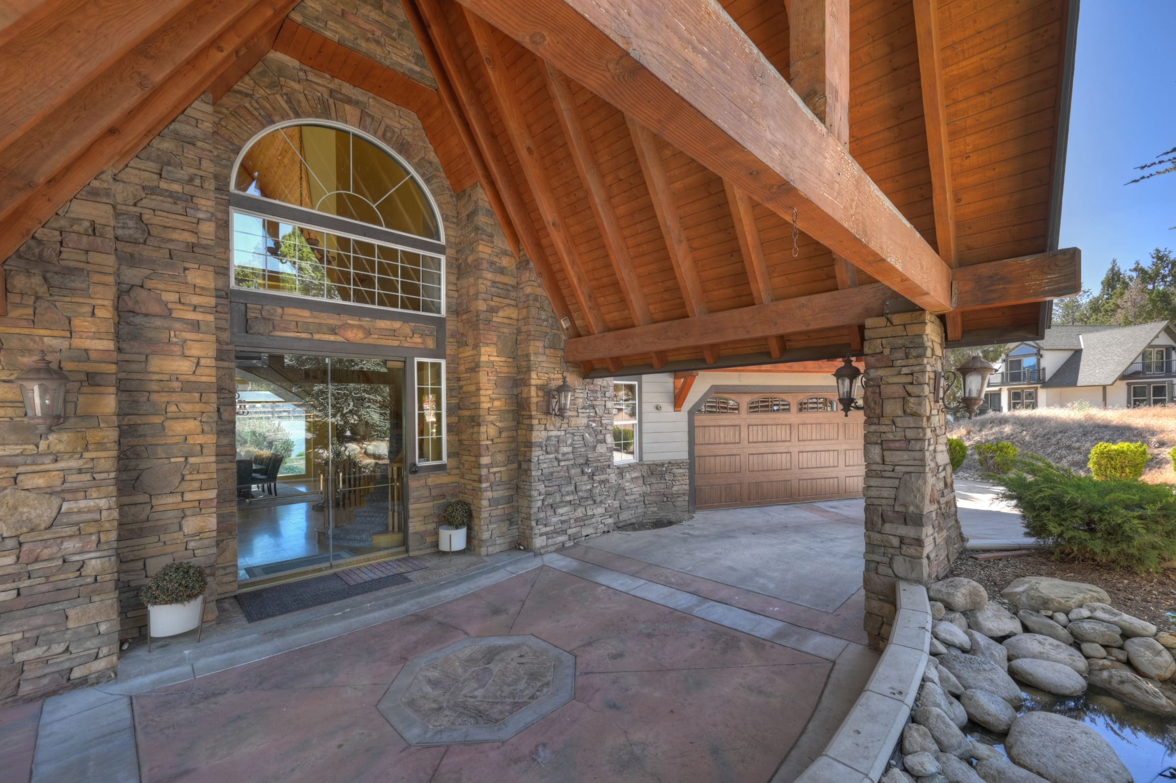 Grand timber-beamed entry with soaring stone archway