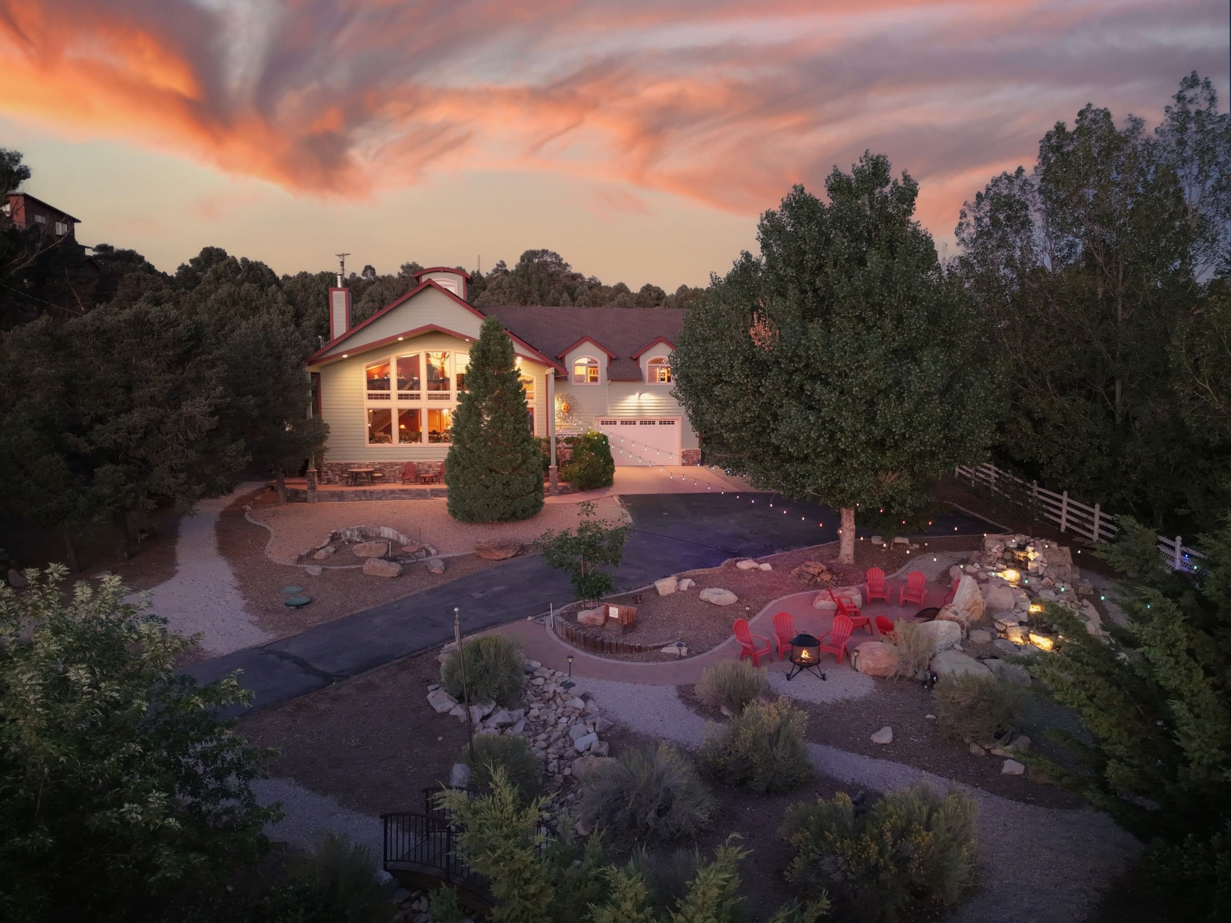 Twilight aerial view with fire pit and lit water feature