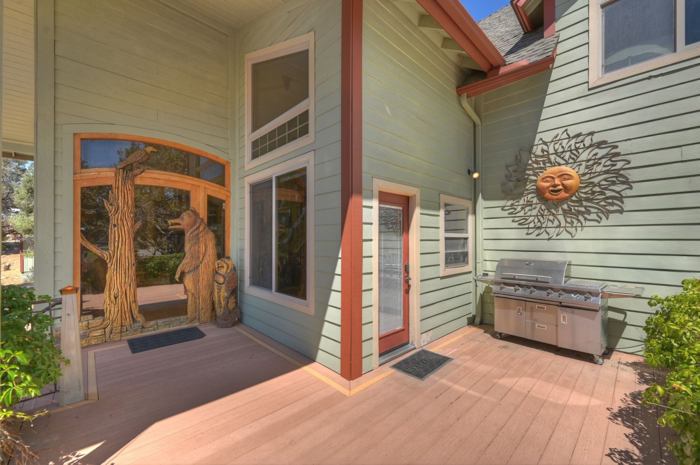 Whimsical bear-carved entry plus built-in outdoor grill deck