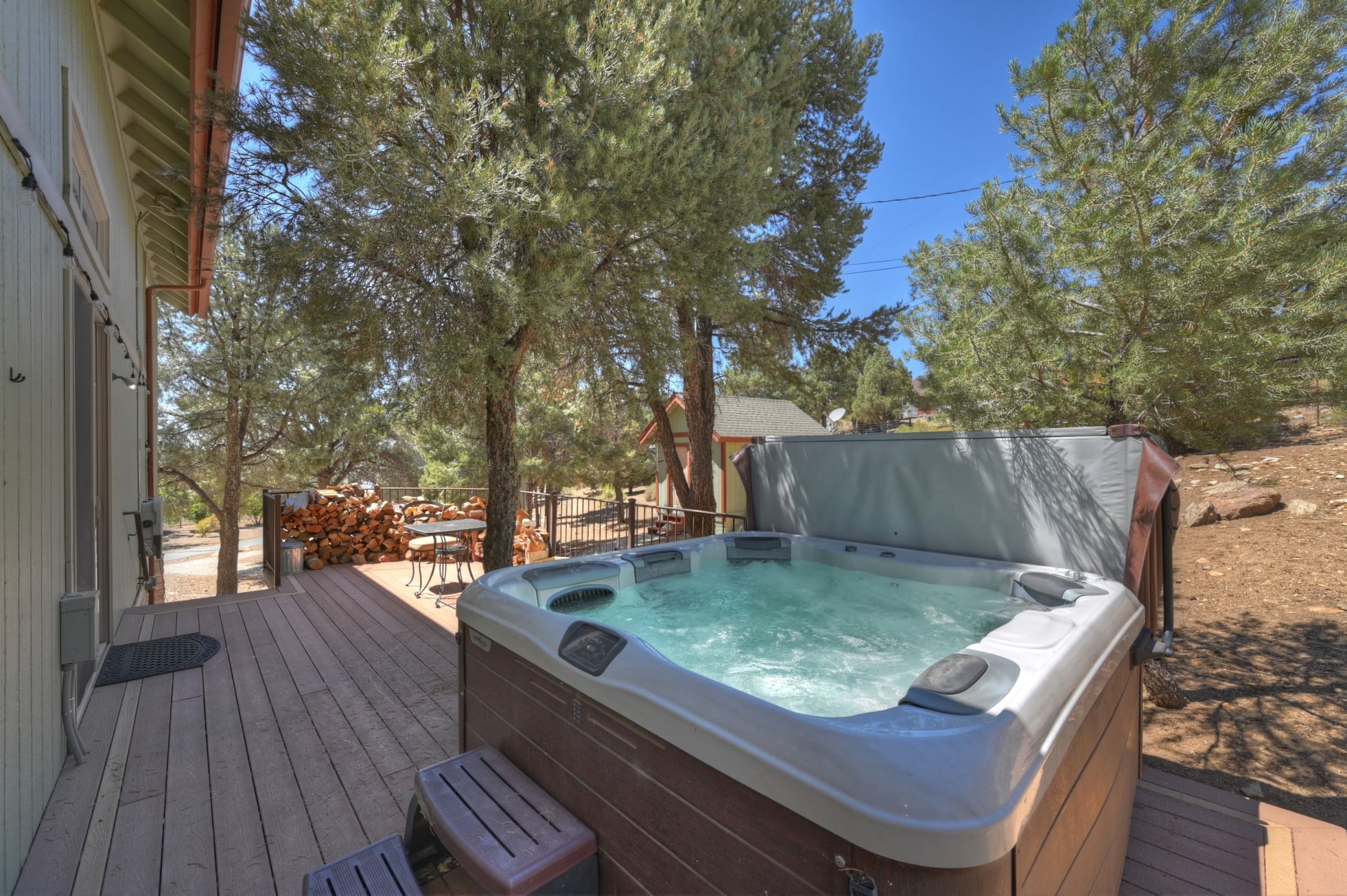 Private deck hot tub surrounded by towering pines