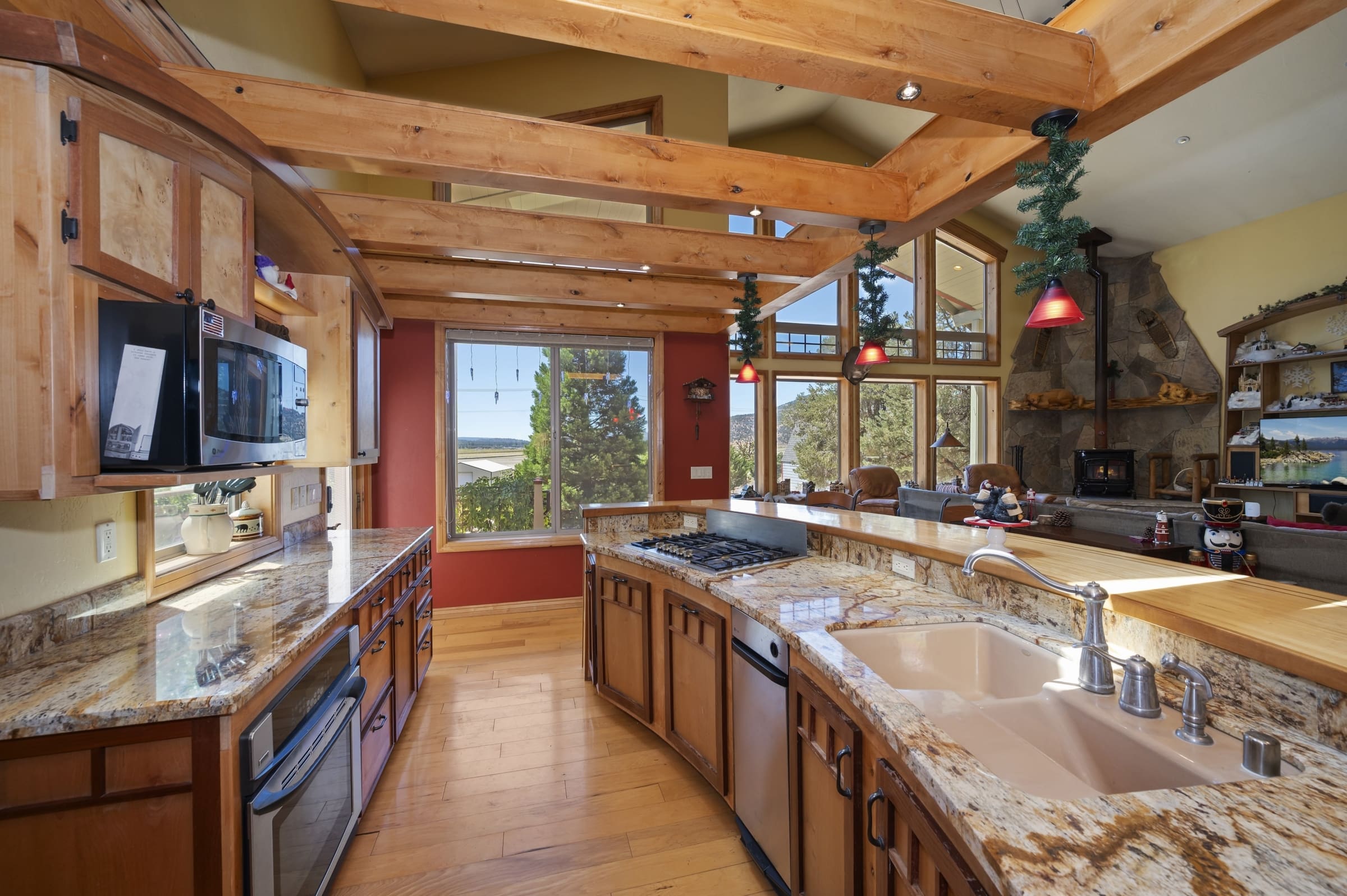 Vaulted timber-beam kitchen with granite island and lake views