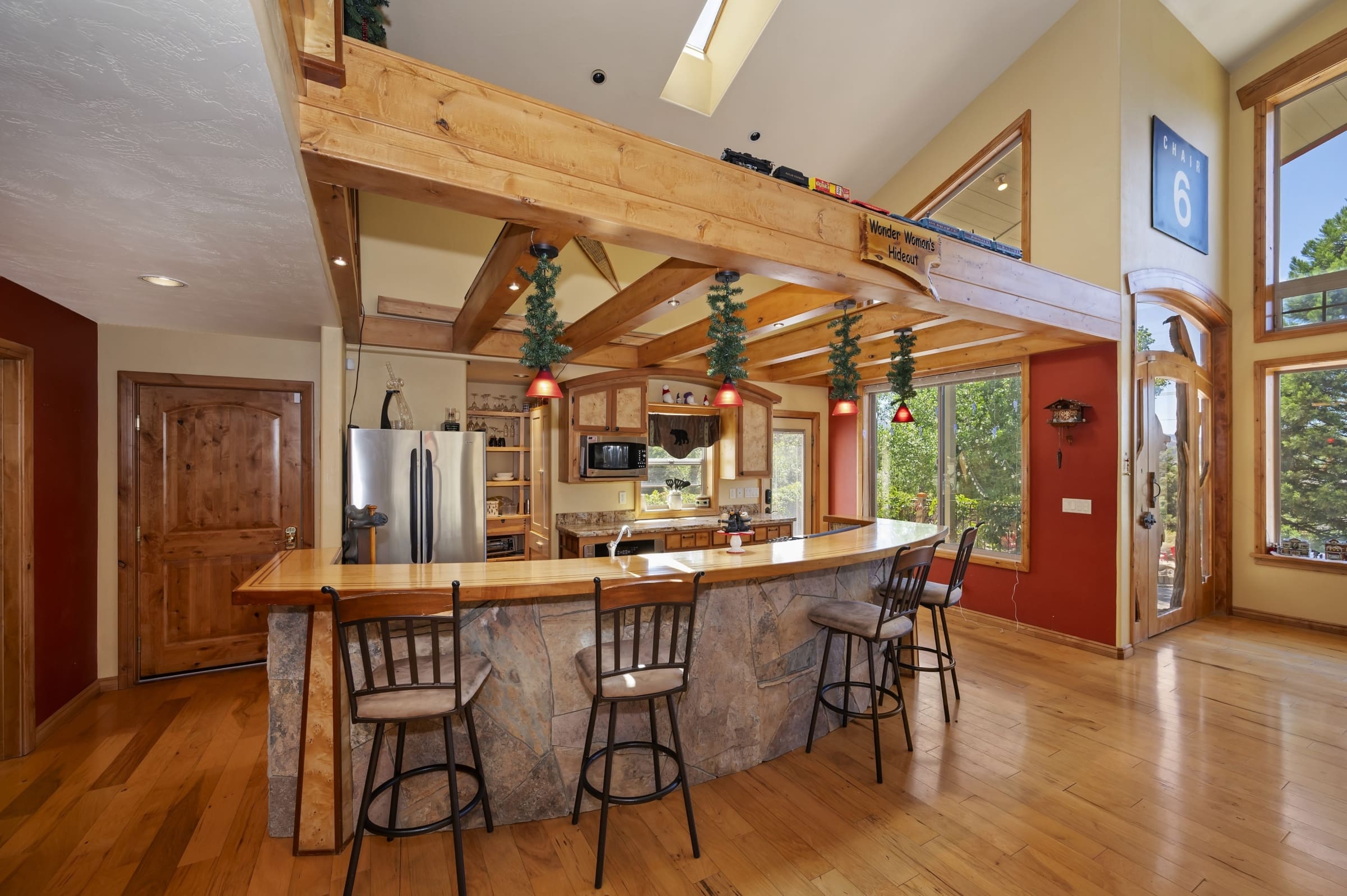 Vaulted timber-beam kitchen with stone breakfast bar seating