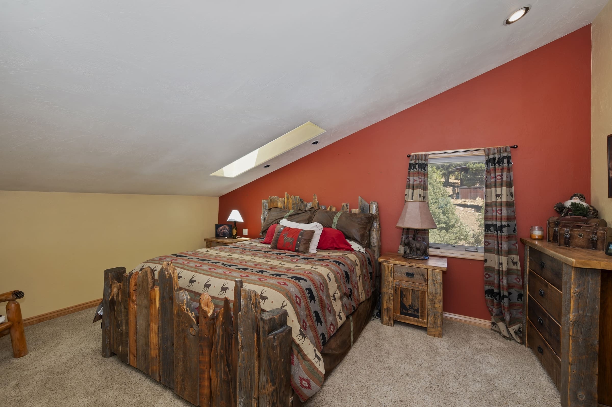 Rustic loft bedroom with vaulted skylight ceiling