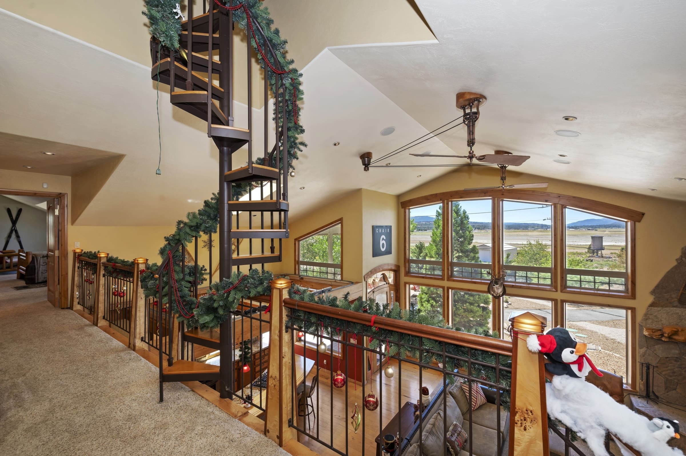 Spiral staircase loft overlooking valley views through arched windows