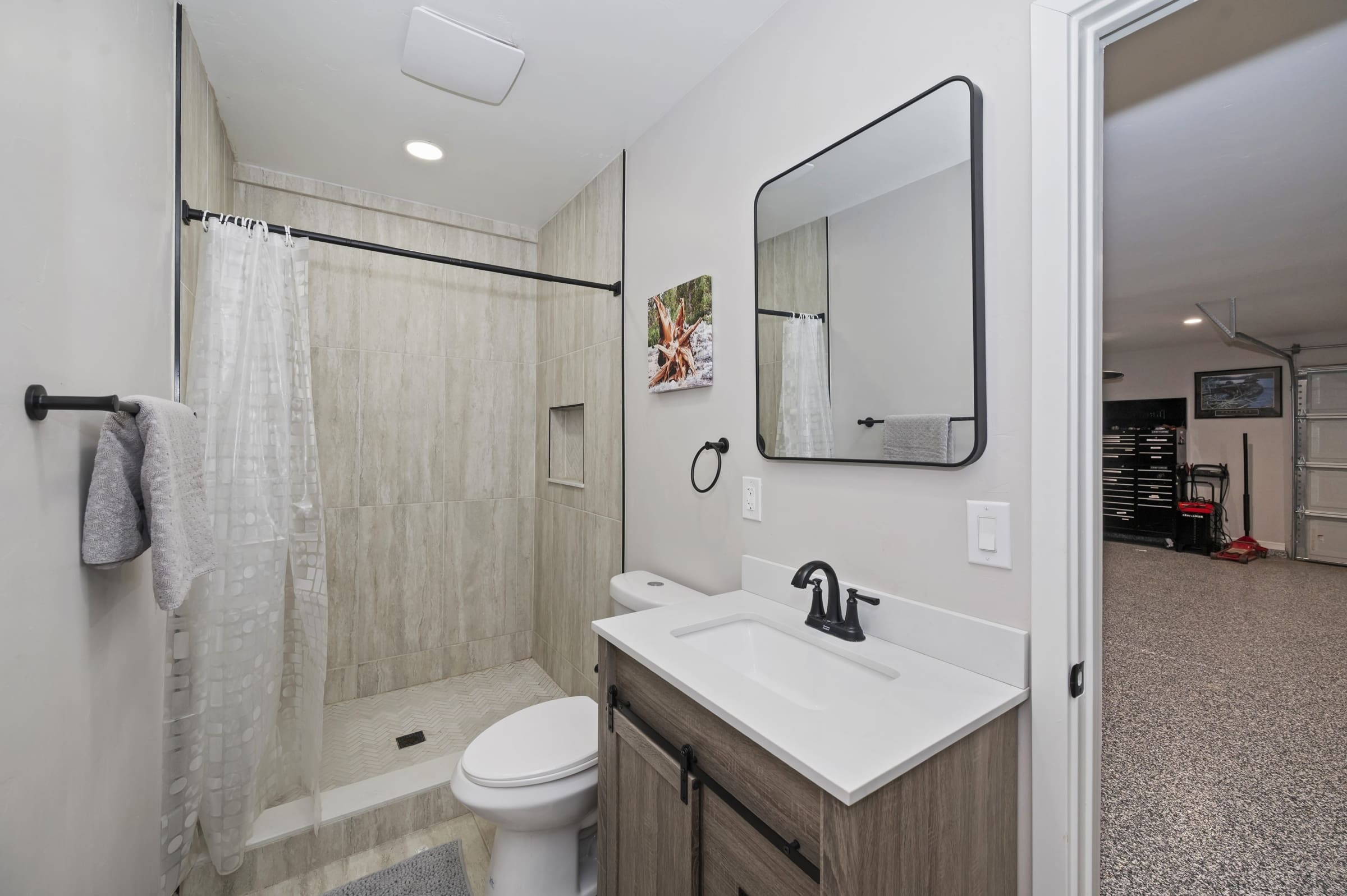 Updated bath with tiled shower and garage access