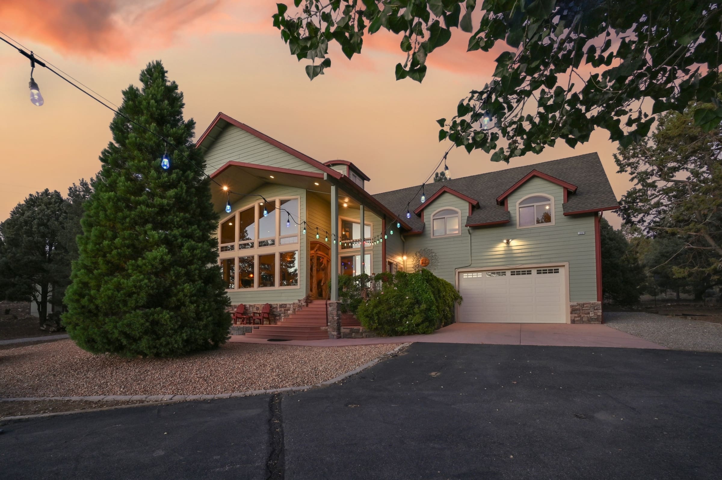 Twilight curb appeal with soaring windows and string lights